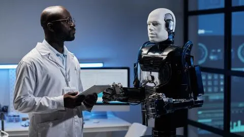 A man tutoring a robot.